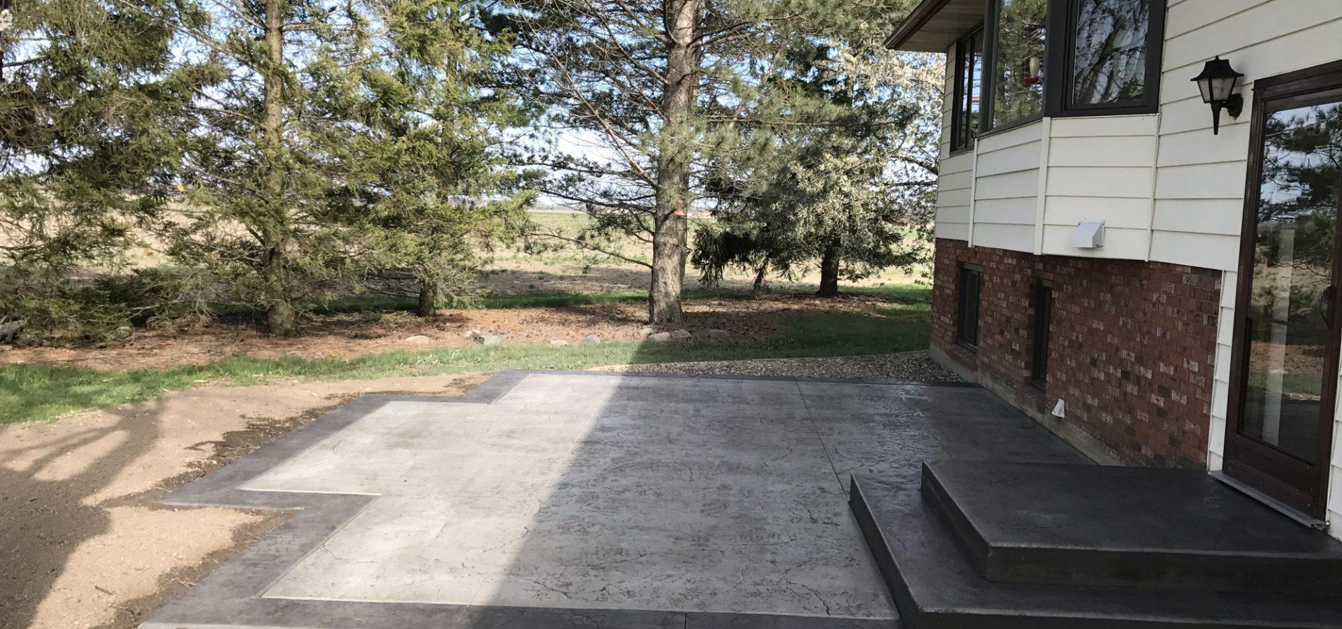 Formed concrete steps on a raised patio with a dark border finish