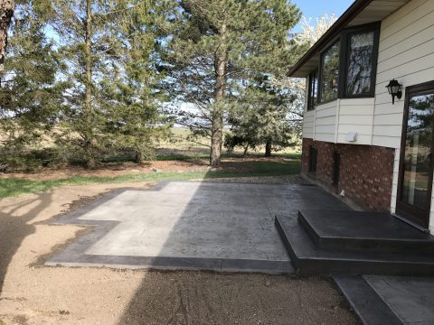 Formed concrete steps on a raised patio with a dark border finish
