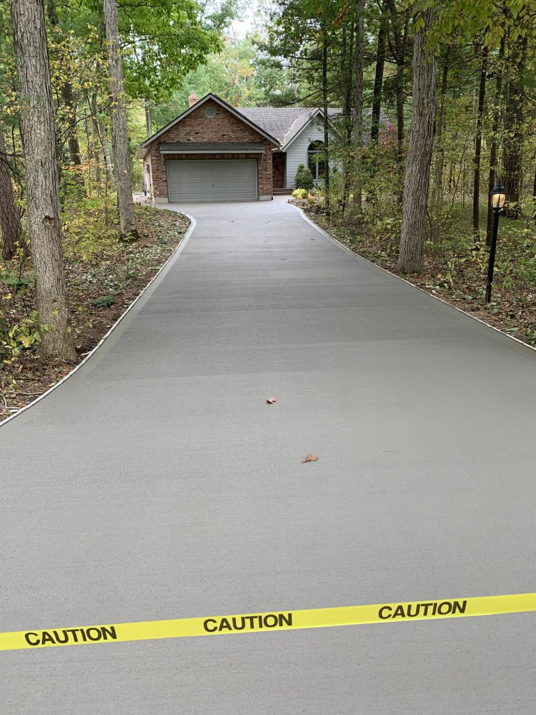 Freshly poured concrete driveway marked with caution tape