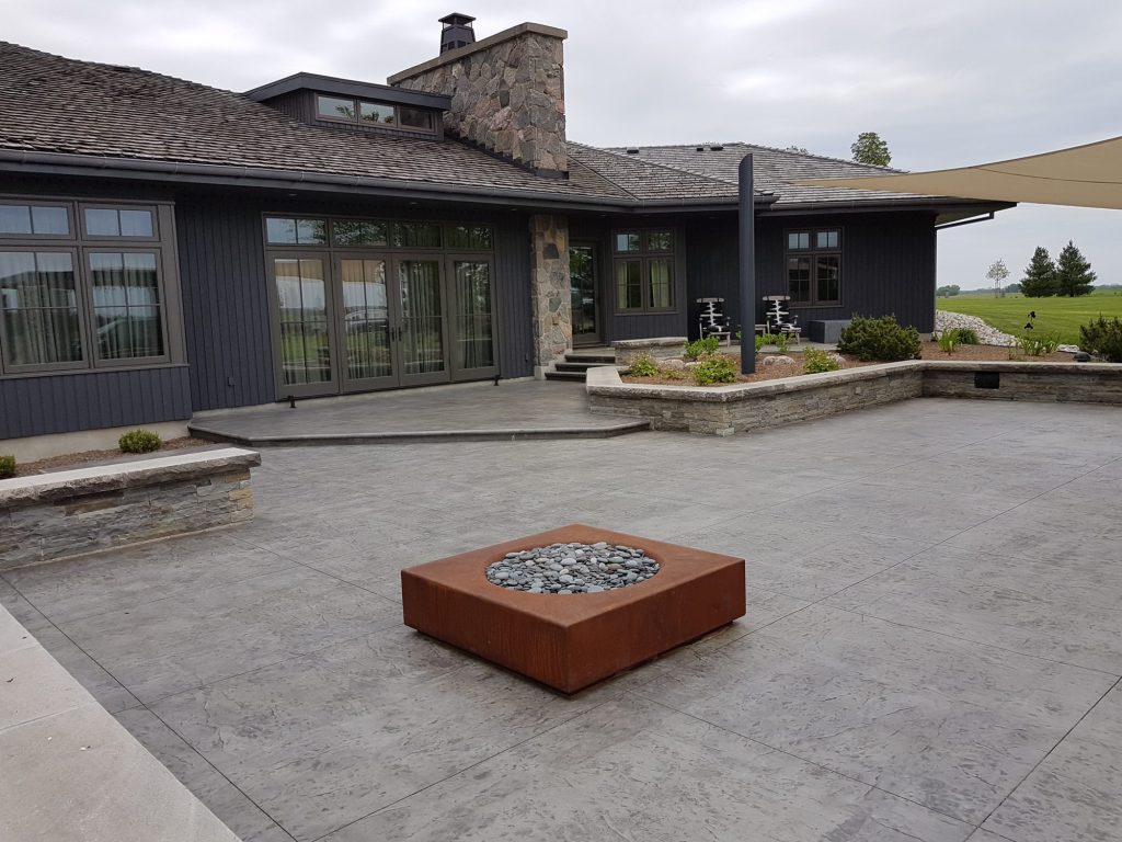 Stamped concrete patio with pergola seating area in Thamesford