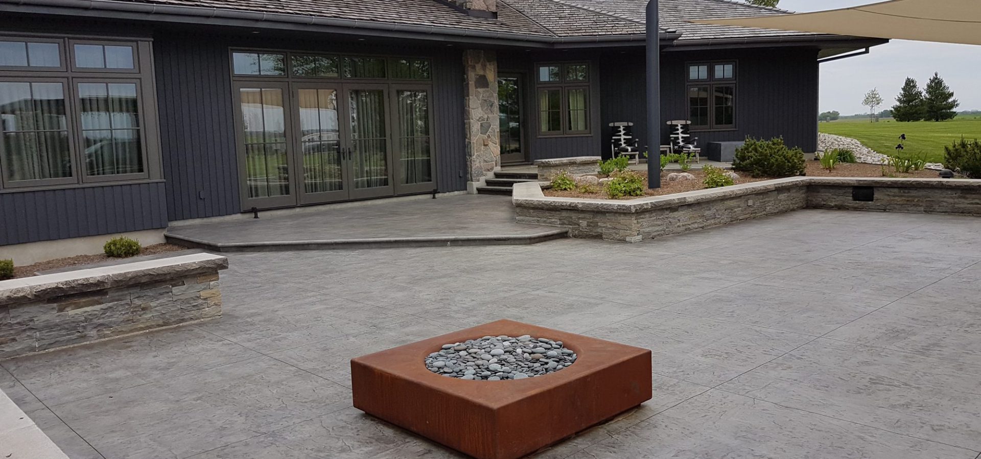 Stamped concrete patio with pergola seating area in Thamesford
