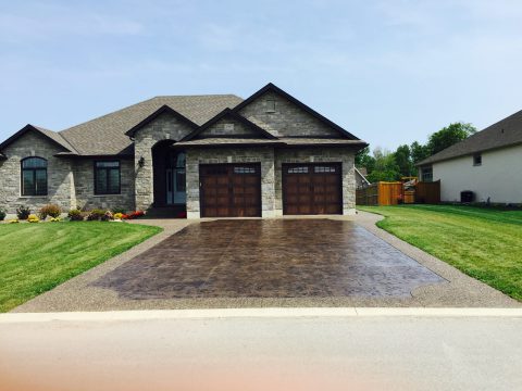 Stamped concrete driveway with decorative border at a stone home