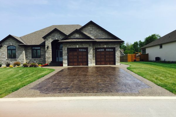 Stamped concrete driveway with decorative border at a stone home