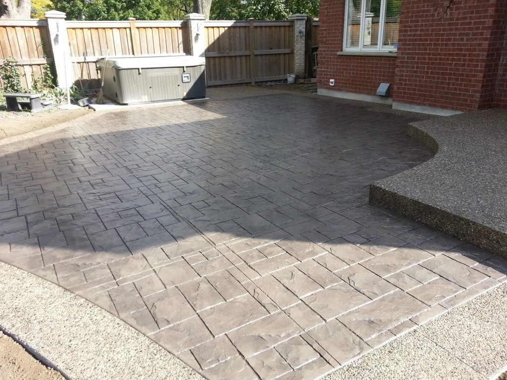 Stamped concrete patio surrounding a hot tub