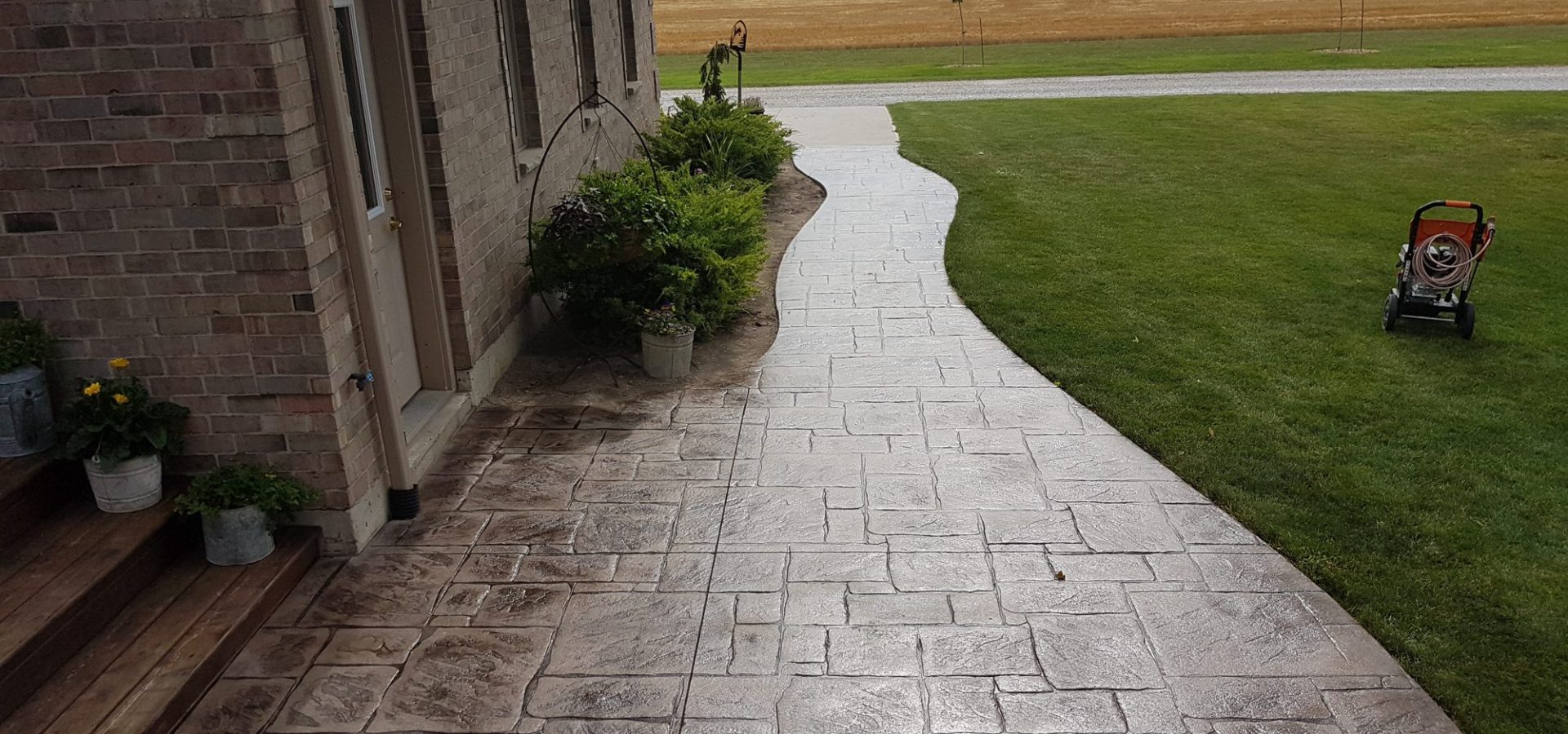Curved stamped concrete walkway beside a home
